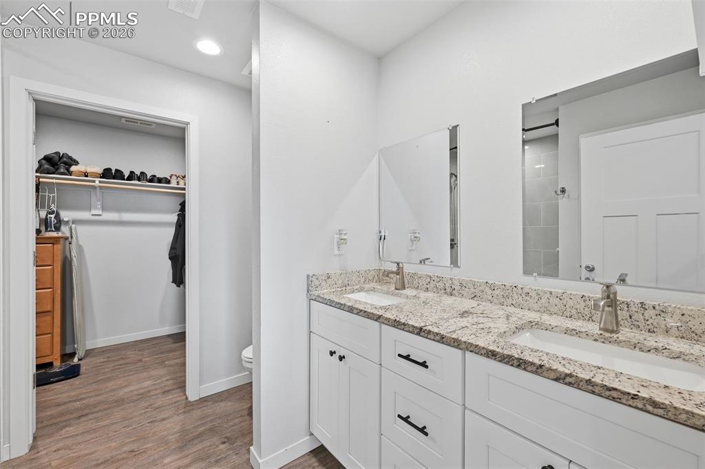 Image 14 of 29: Primary bathroom with double vanities and walk in closet