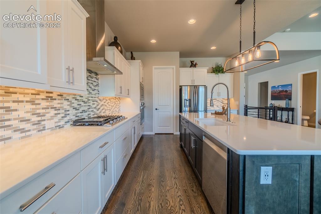 Image 10 of 50: Spacious kitchen featuring an expansive island with an undermount sink, sta