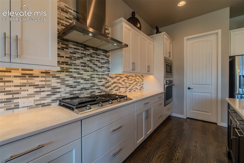 Image 11 of 50: Modern kitchen featuring wood-finish flooring and light-toned cabinetry