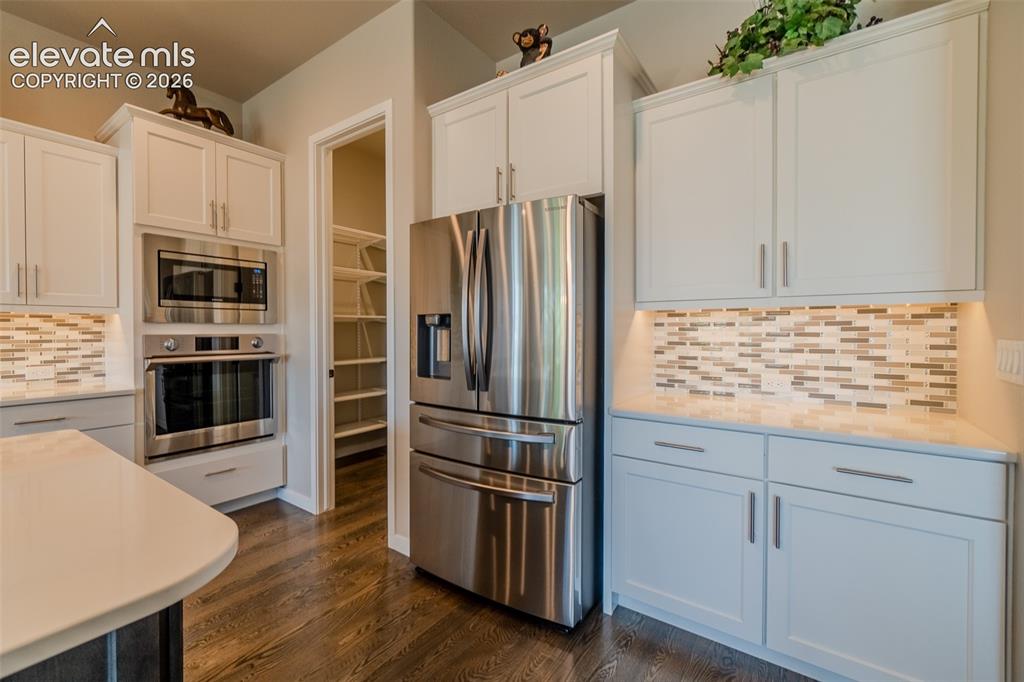 Image 13 of 50: Modern kitchen featuring white shaker cabinetry, stainless steel appliances