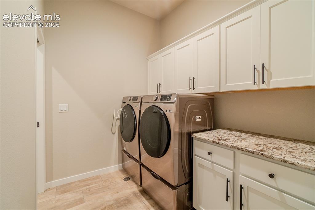 Image 19 of 50: Dedicated laundry area featuring light wood-finish flooring