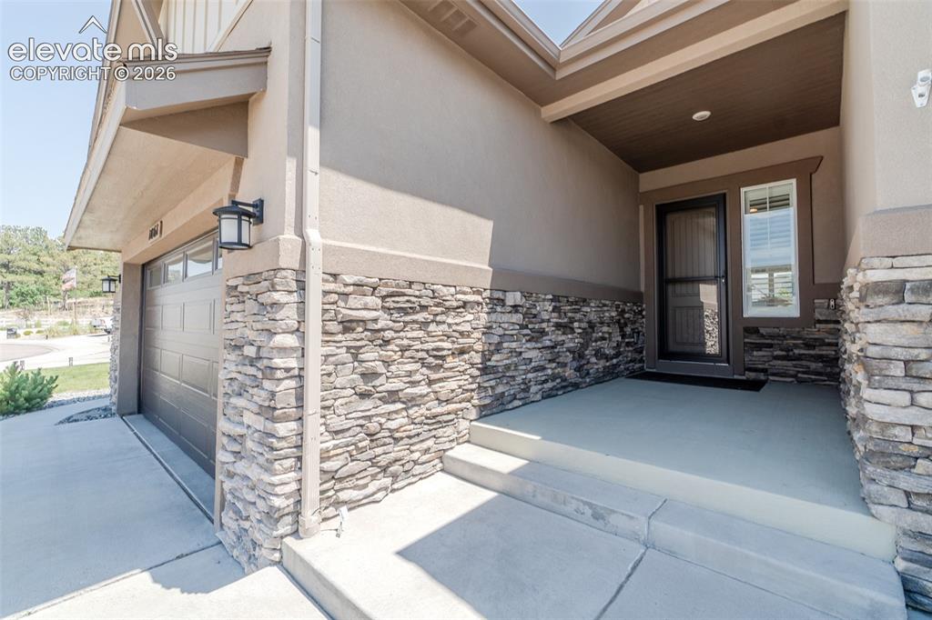 Image 2 of 50: Inviting covered entry featuring a paneled front door with a full-light sto