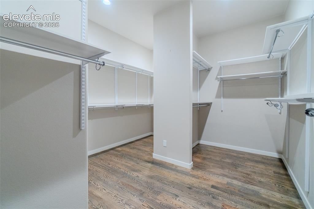 Image 20 of 50: Spacious walk-in closet featuring wood-finish flooring, white adjustable sh