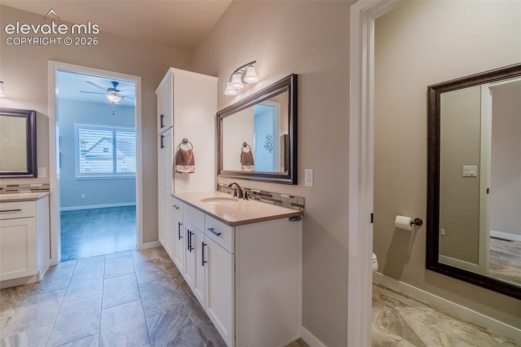 Image 22 of 50: Double vanity with white cabinetry, light countertops, and dark bronze hard