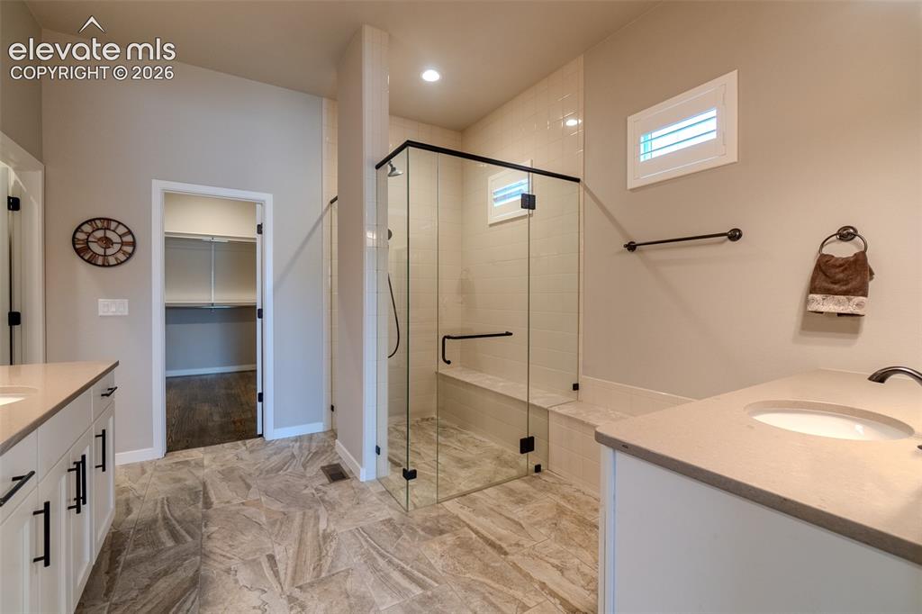 Image 24 of 50: Contemporary bathroom with a glass-enclosed shower featuring a built-in ben