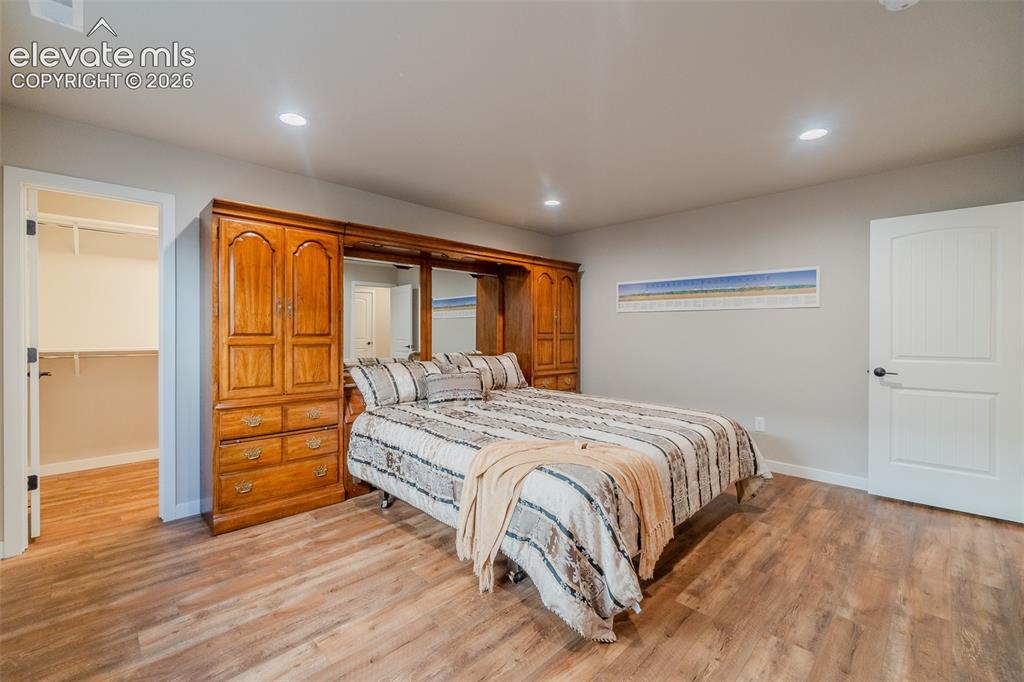 Image 40 of 50: Spacious room featuring wood-finish flooring, recessed lighting, a built-in