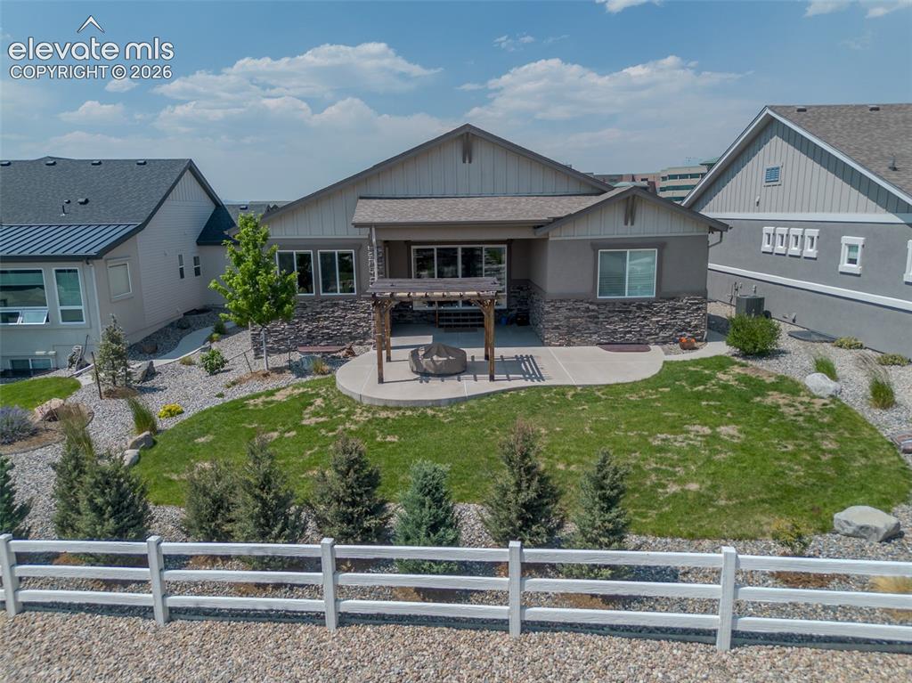 Image 49 of 50: Expansive backyard featuring a manicured lawn, a concrete patio, and a wood
