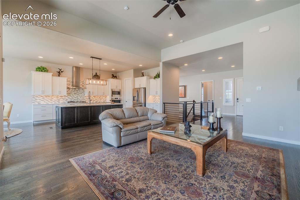 Image 6 of 50: Open-concept living area with dark wood-finish flooring