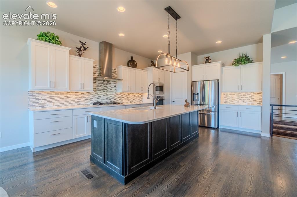 Image 8 of 50: Spacious kitchen featuring an oversized island with a light-toned counterto