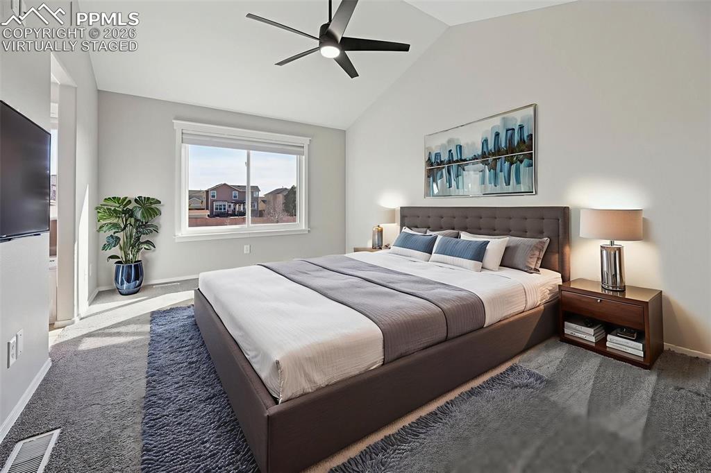 Image 16 of 49: Virtually staged, primary bedroom with vaulted ceilings, large walk-in desi