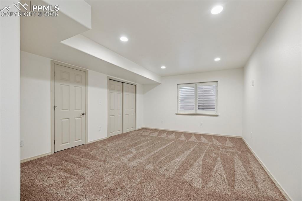 Image 32 of 49: Basement family room with plantation shutters