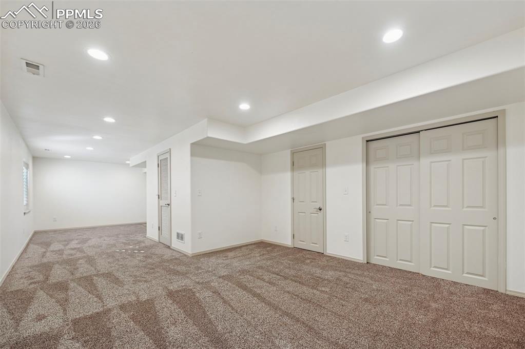Image 33 of 49: Basement family room with plantation shutters