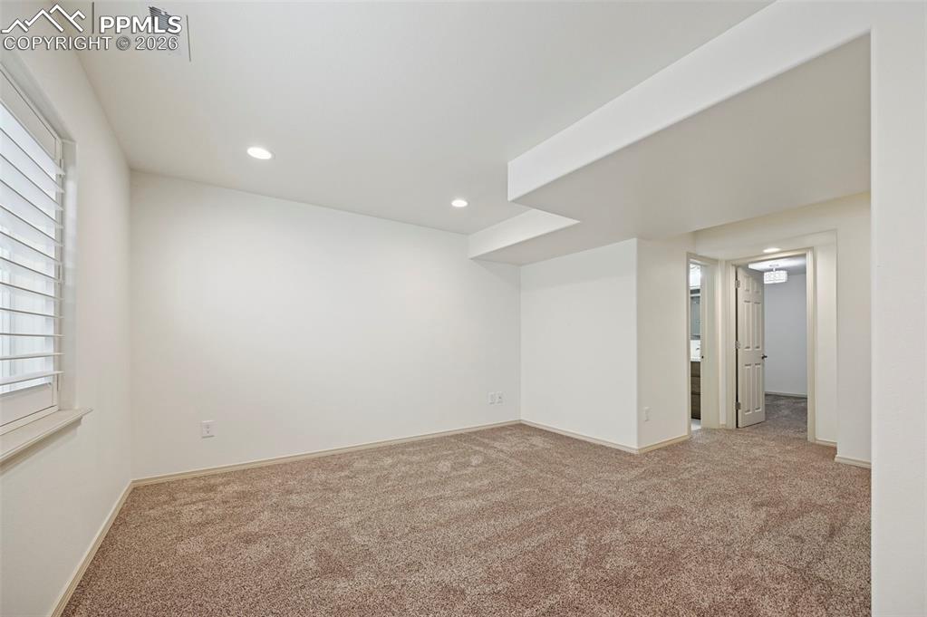 Image 34 of 49: Basement family room with plantation shutters
