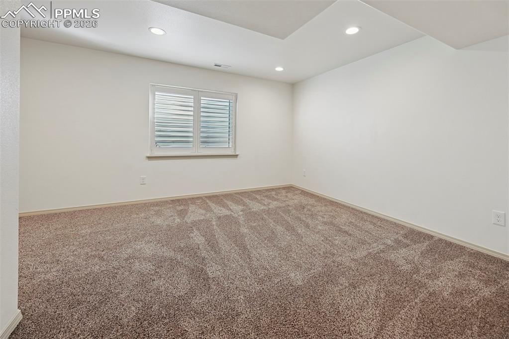 Image 35 of 49: Basement family room with plantation shutters