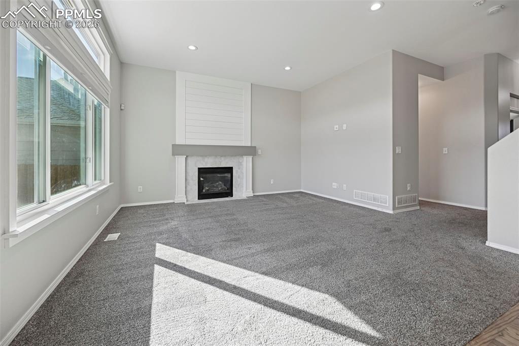 Image 7 of 49: Living room with beautiful fireplace, surrounded by hexagon accent tile an