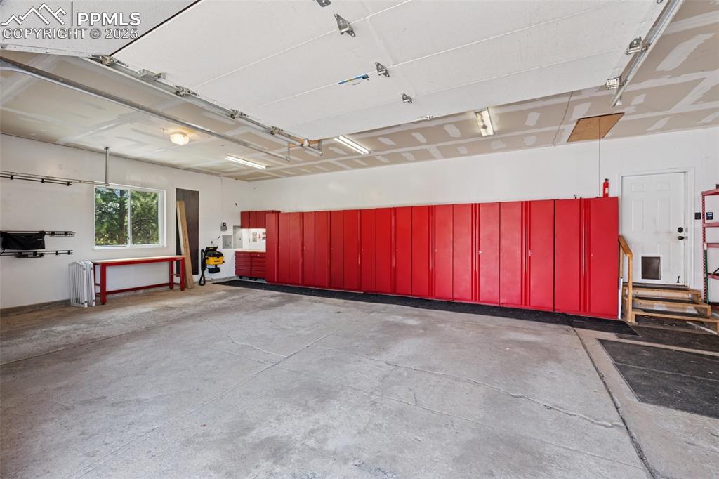 Image 39 of 49: Cabinets and Matching Workbench in 3 Car Attached Garage.  Included!!