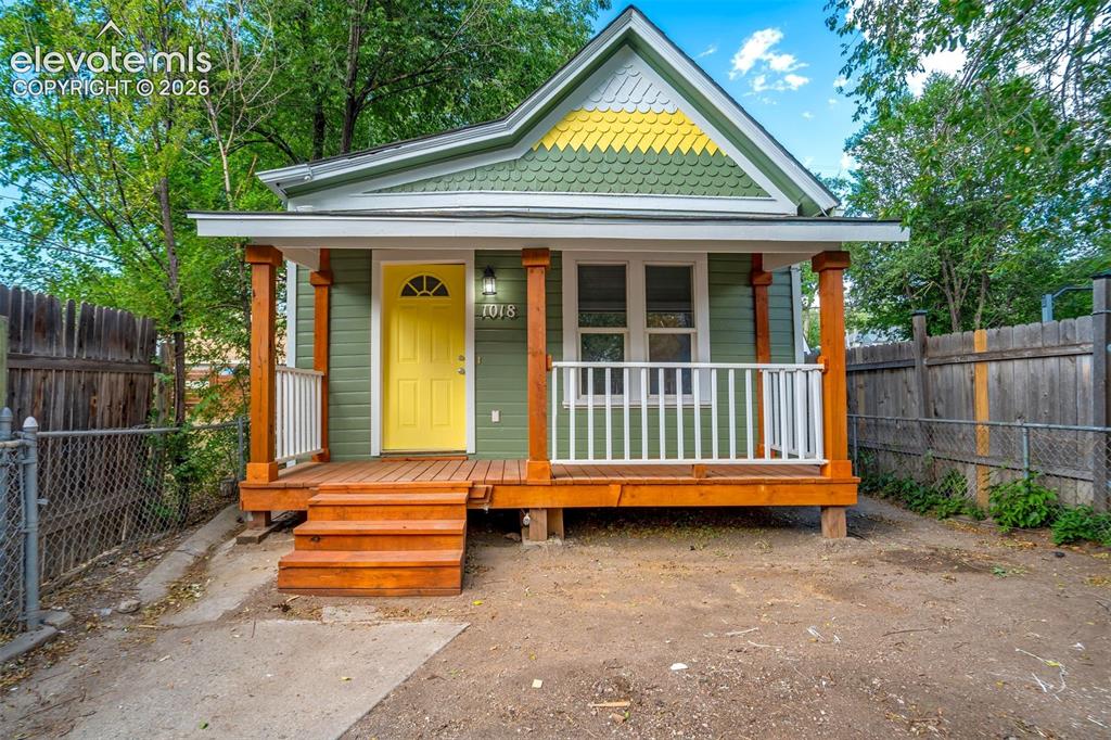 Image 1 of 28: Charming exterior with vibrant green siding and yellow shingle accents