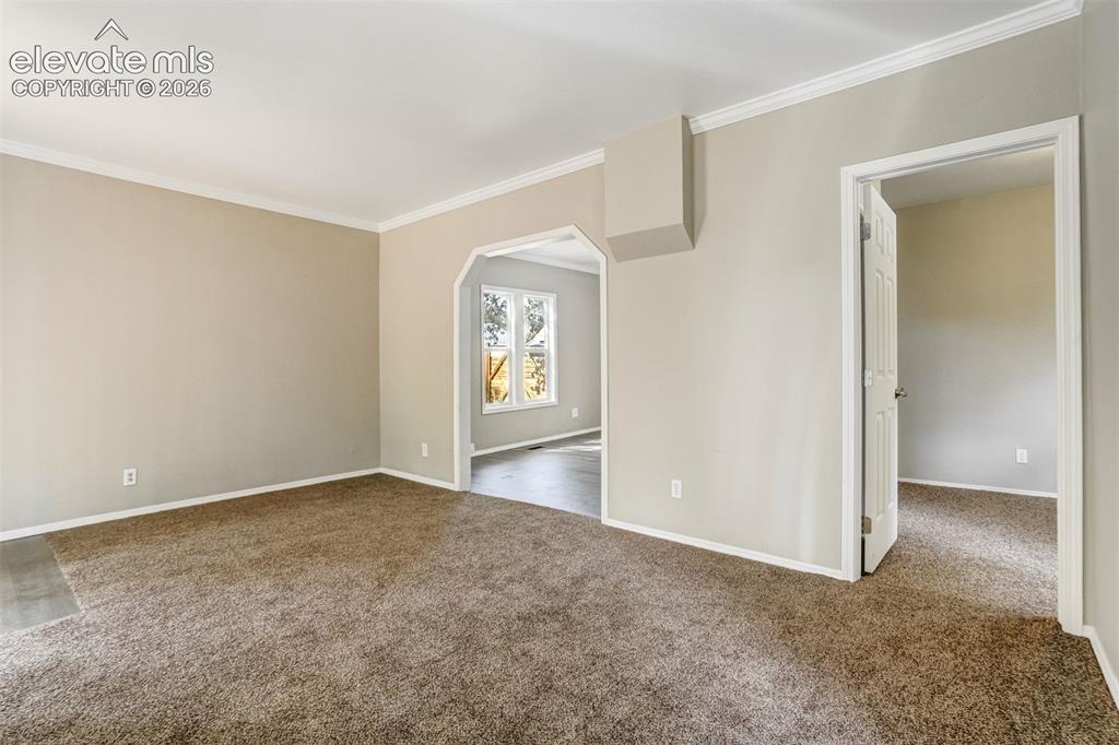 Image 10 of 28: Carpeted interior space featuring neutral wall paint, white crown molding,