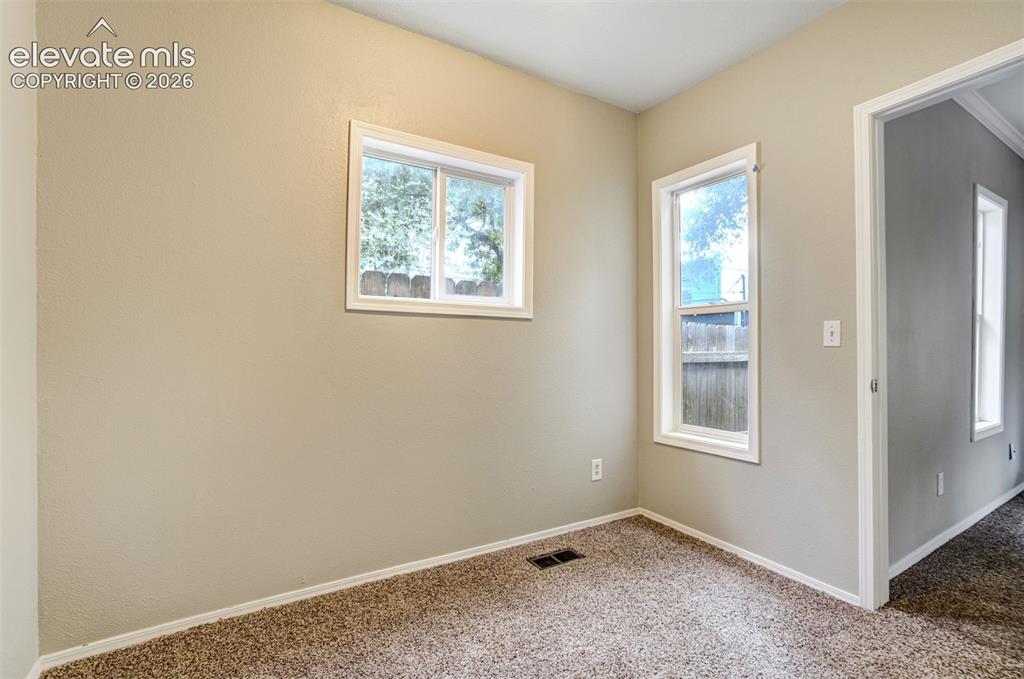 Image 21 of 28: Neutral painted walls complement the textured brown carpeting