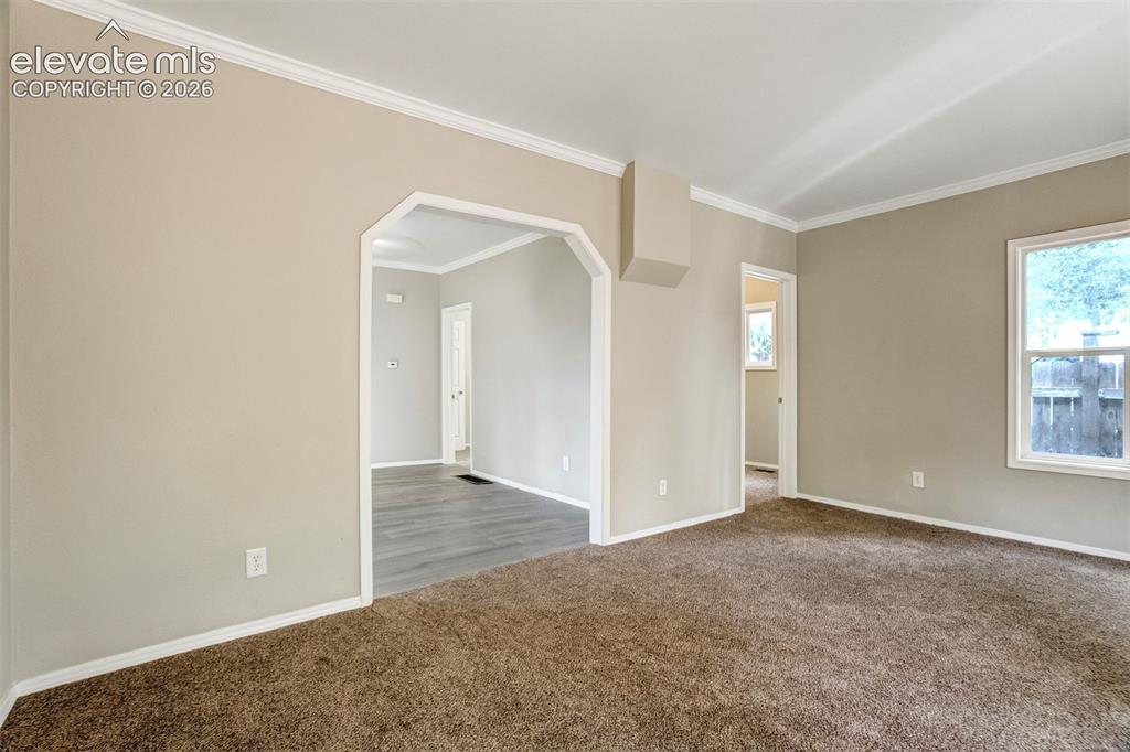 Image 8 of 28: Interior room with warm-toned carpet flooring