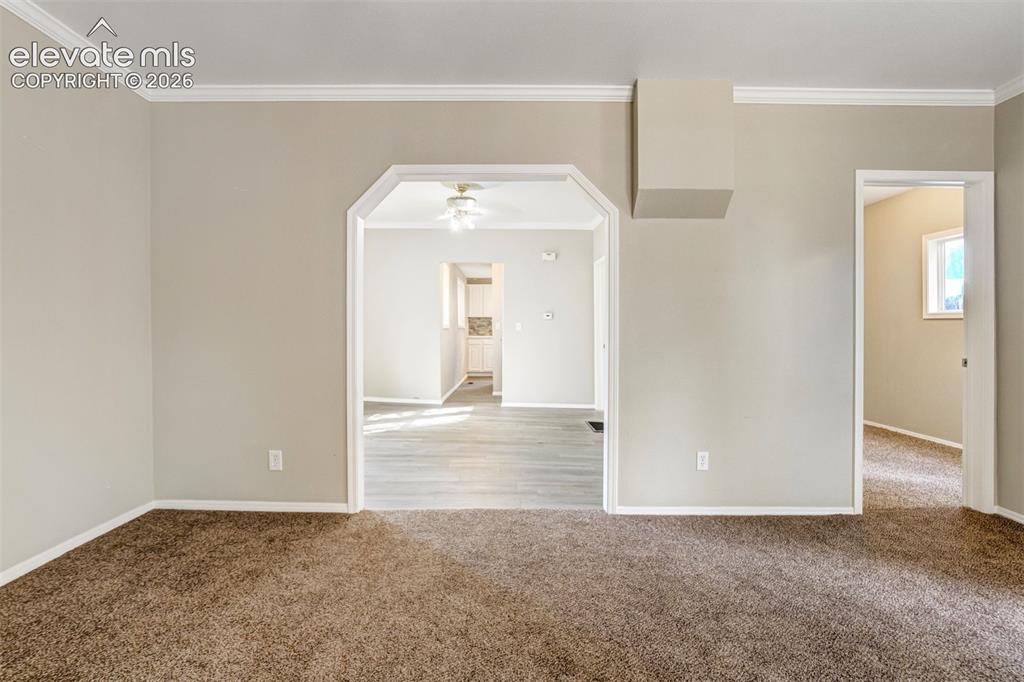 Image 9 of 28: Neutral-toned walls with contrasting white baseboards and crown molding