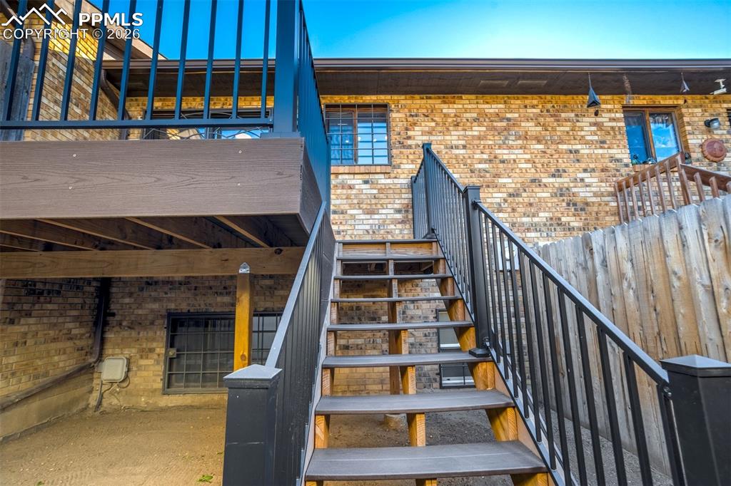 Image 31 of 37: The property features a brick exterior with a wooden privacy fence