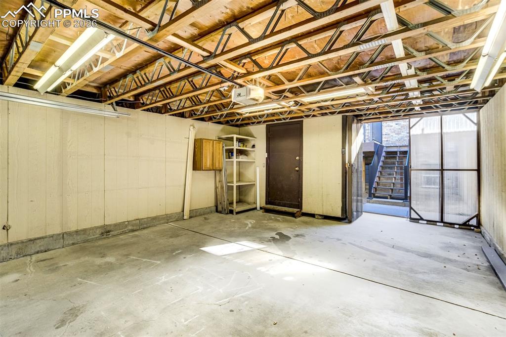Image 36 of 37: Utility space featuring a concrete floor, exposed wood ceiling beams, and f