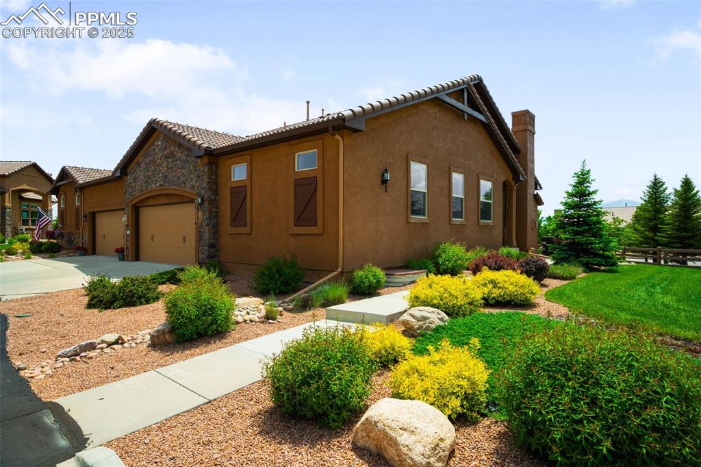 Image 2 of 37: View of front of home featuring an attached garage, stucco siding, concrete
