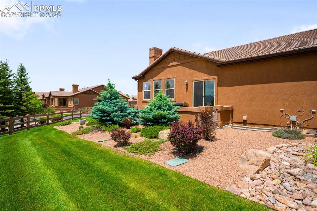 Image 33 of 37: Back of property featuring a chimney, stucco siding, and a tiled roof