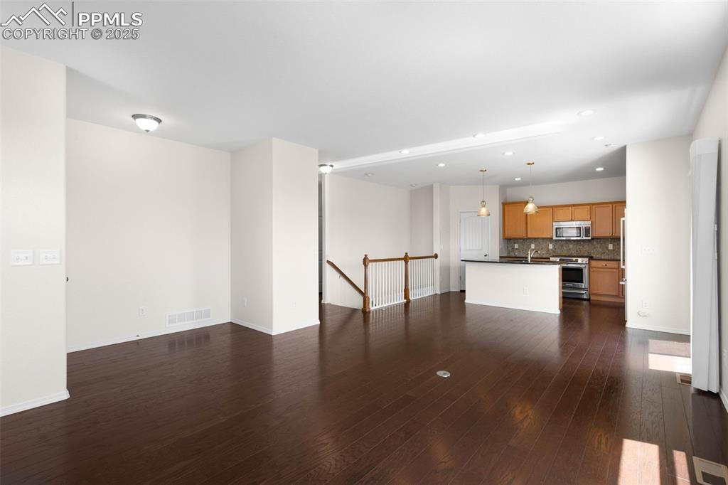 Image 6 of 37: Unfurnished living room with dark wood finished floors