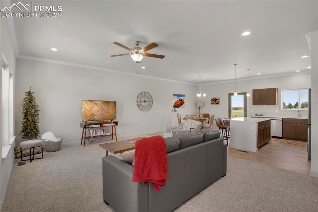 Image 5 of 25: Living area with recessed lighting, light colored carpet, ceiling fan, and