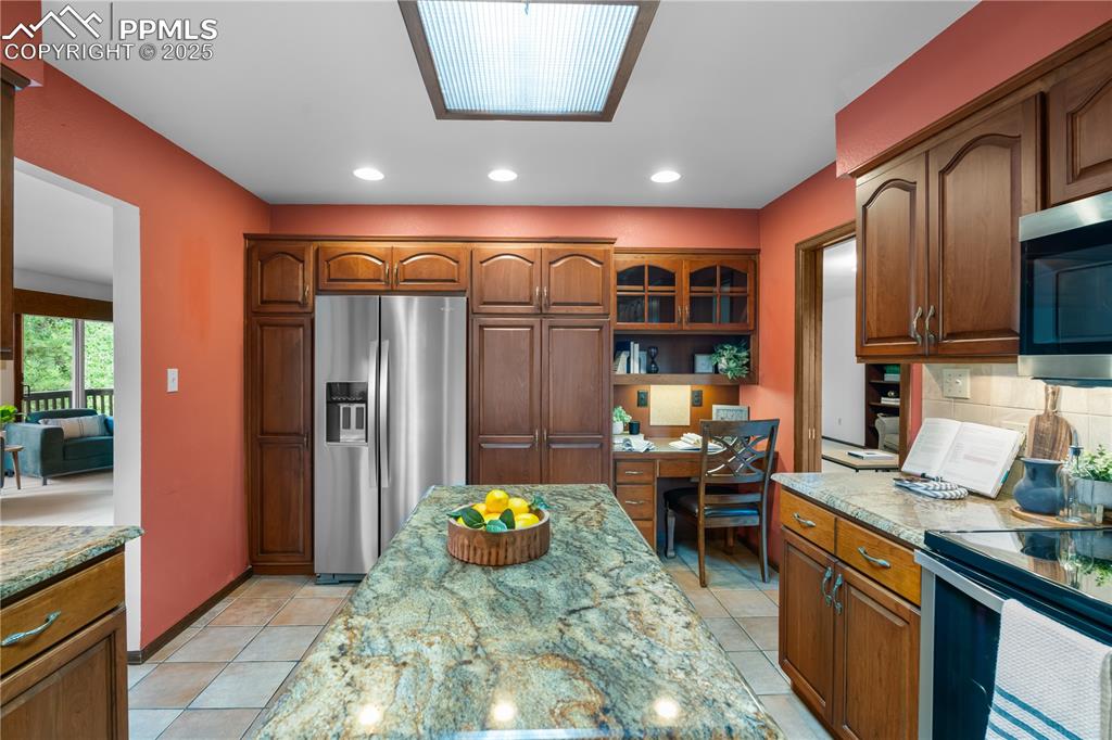 Image 12 of 44: Custom cabinets and updated appliances provide a great kitchen experience.
