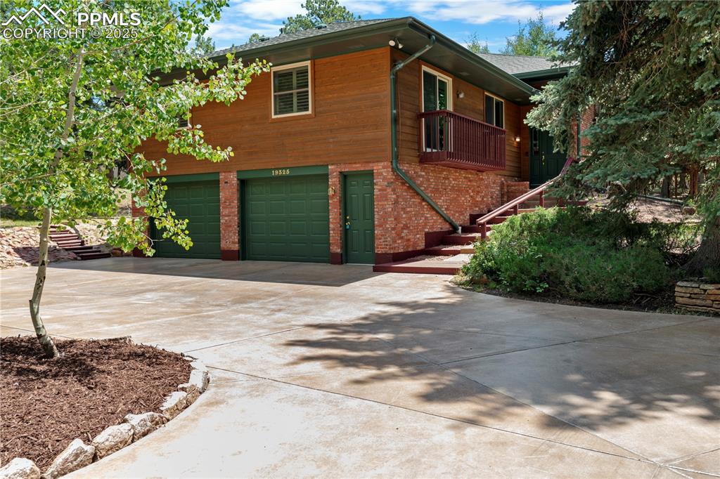 Image 2 of 44: Large circular concrete driveway and welcoming entry walkway.