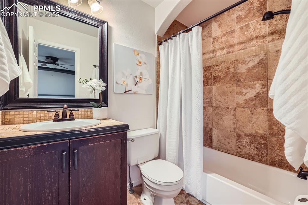 Image 17 of 28: Bathroom with vanity, shower / tub combo with curtain, ceiling fan, and tas