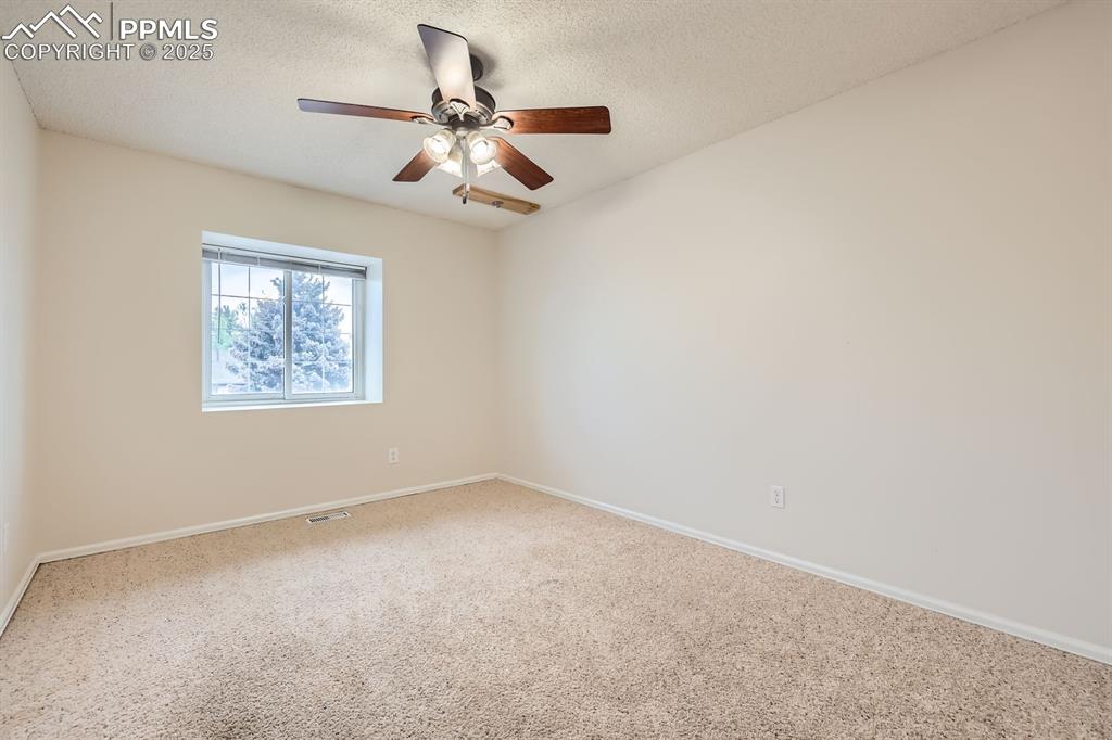 Image 19 of 28: Carpeted spare room featuring ceiling fan and a textured ceiling
