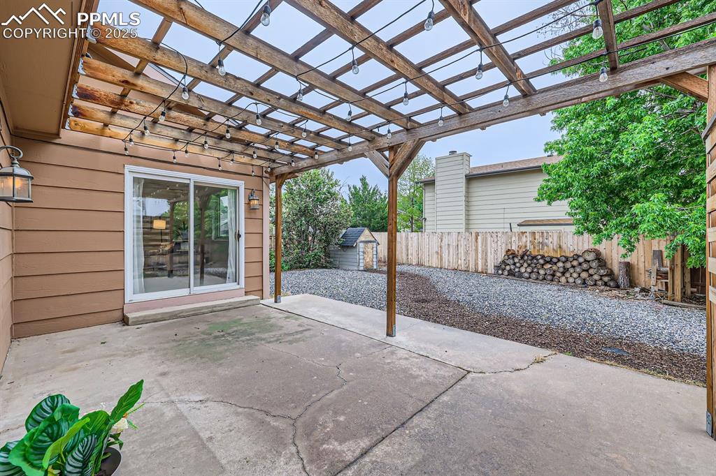 Image 27 of 28: Fenced backyard featuring a shed, a patio, and a pergola