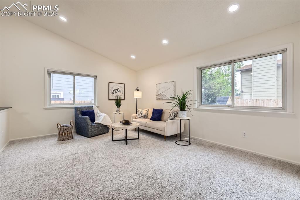 Image 5 of 28: Living area featuring lofted ceiling, carpet flooring, and recessed lightin