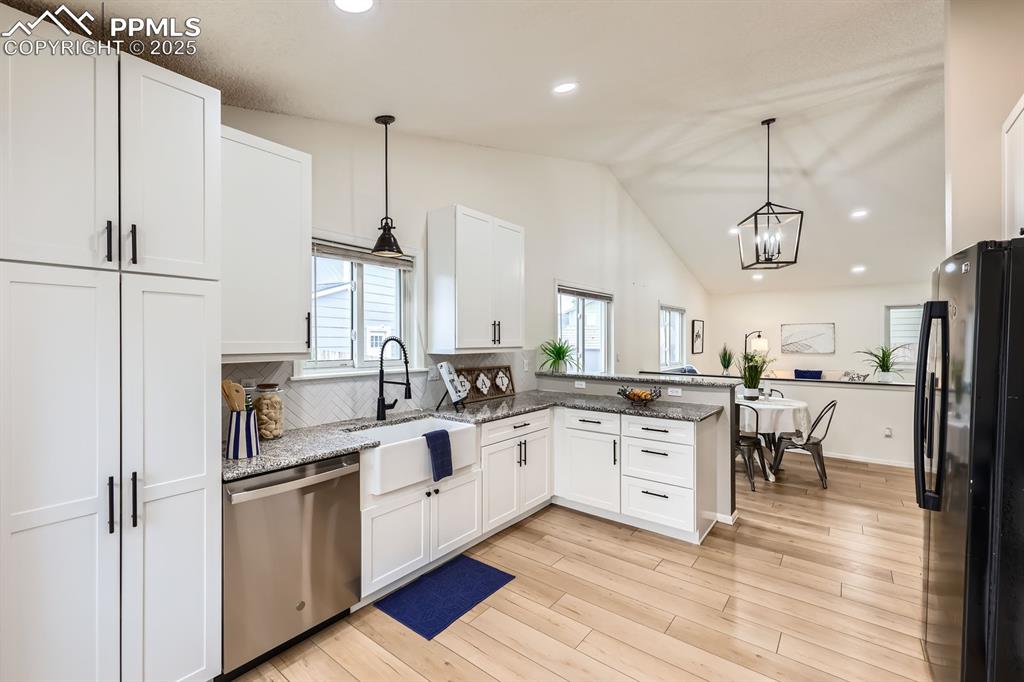Image 7 of 28: Kitchen with freestanding refrigerator, recessed lighting, stainless steel