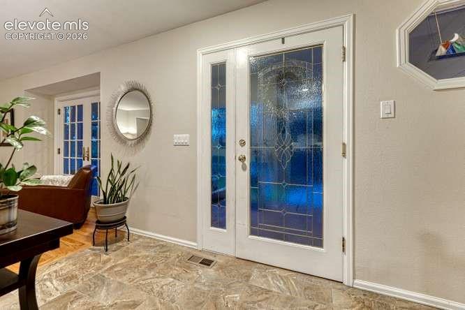 Image 18 of 49: Welcoming leaded glass front door allows in natural light.