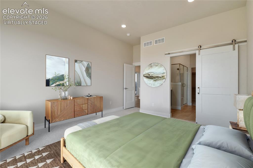 Image 12 of 50: En-suite bath with barn door. Virtually Staged