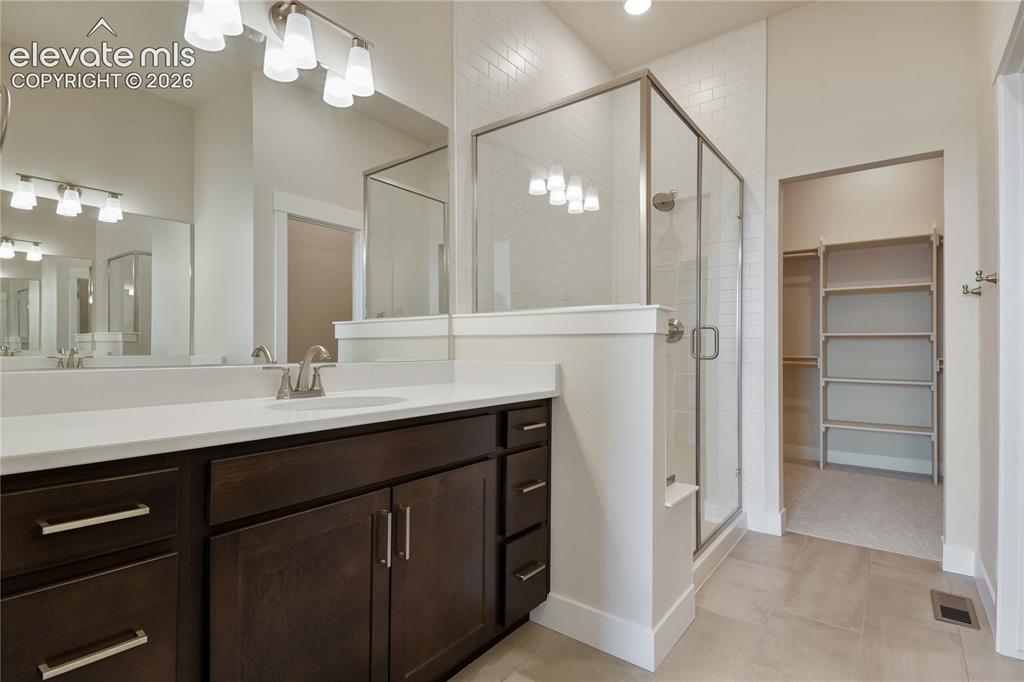 Image 13 of 50: Oversized double vanities and large shower with floor to ceiling tile