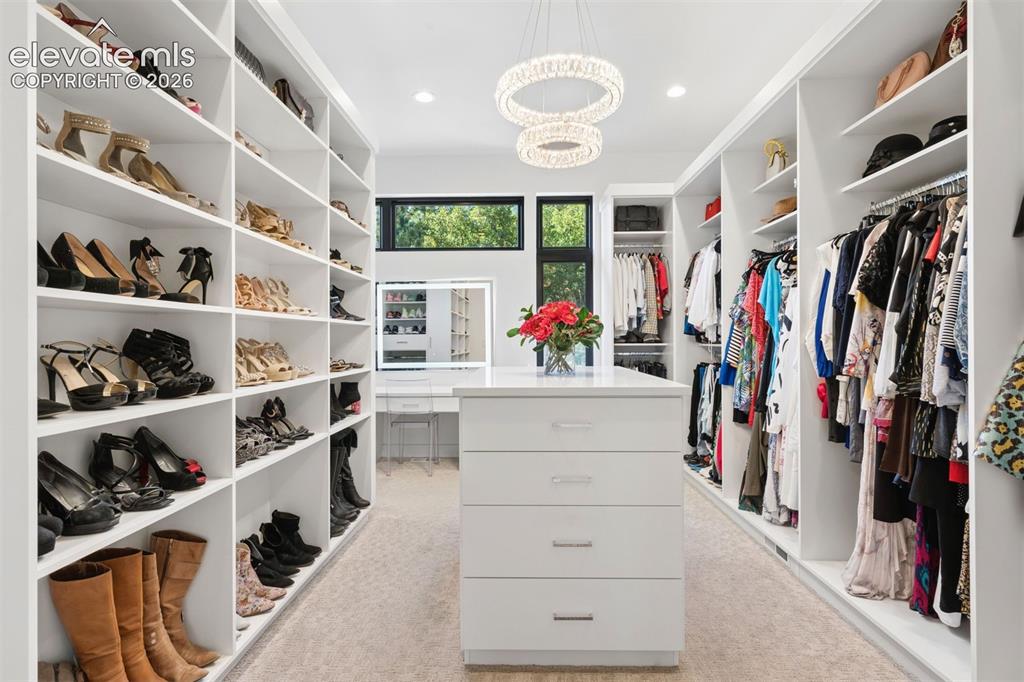 Image 6 of 50: A stunning, boutique-inspired dressing room with custom cabinetry, a centra