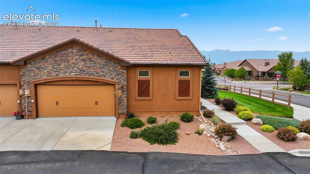 Image 4 of 37: View of garage door and entry path with the West view of the mountains