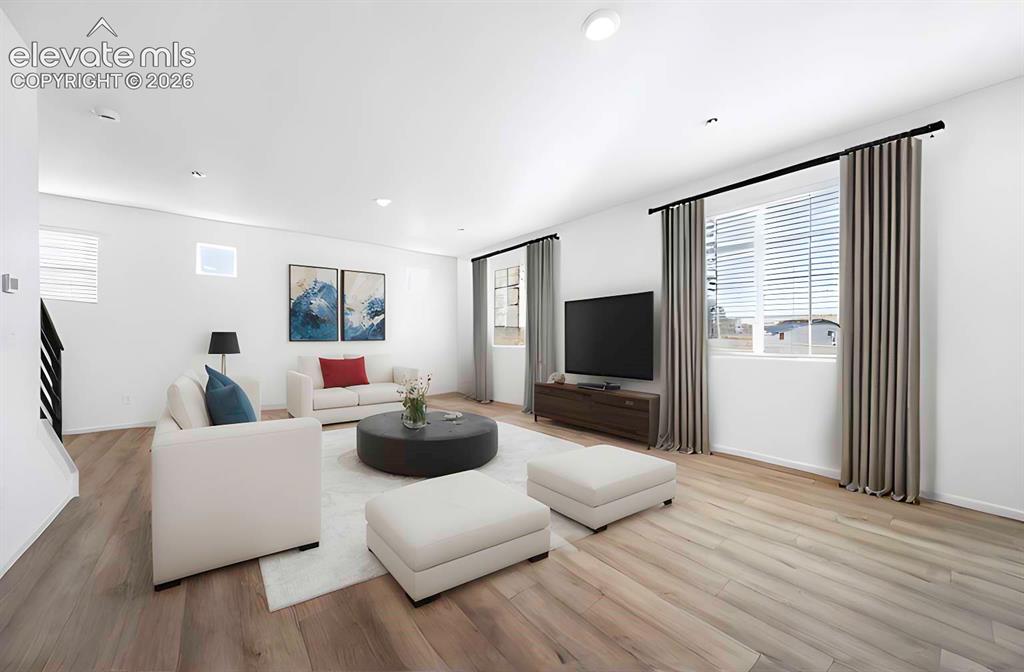 Image 7 of 15: Bright living space featuring wood-finish flooring, recessed lighting, mult