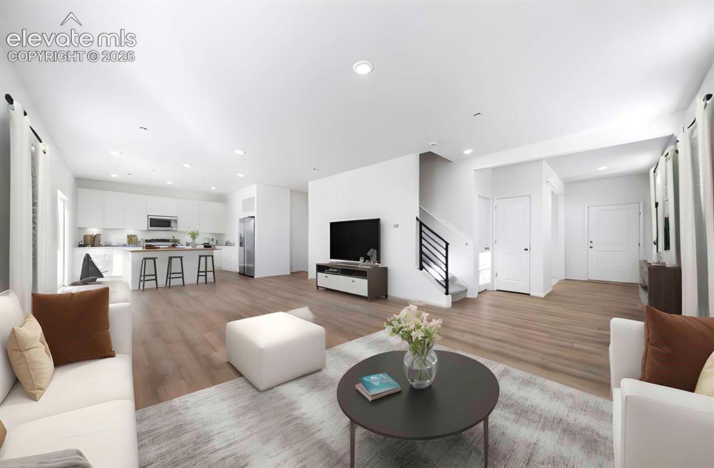 Image 8 of 15: Open-concept living space featuring wood-finish flooring, recessed lighting