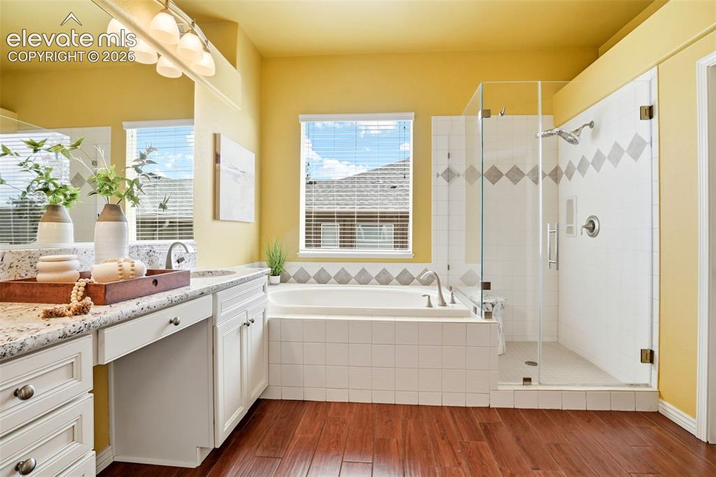 Image 12 of 41: Bright and spacious primary bathroom!  Deep soaking tub, glass shower with 