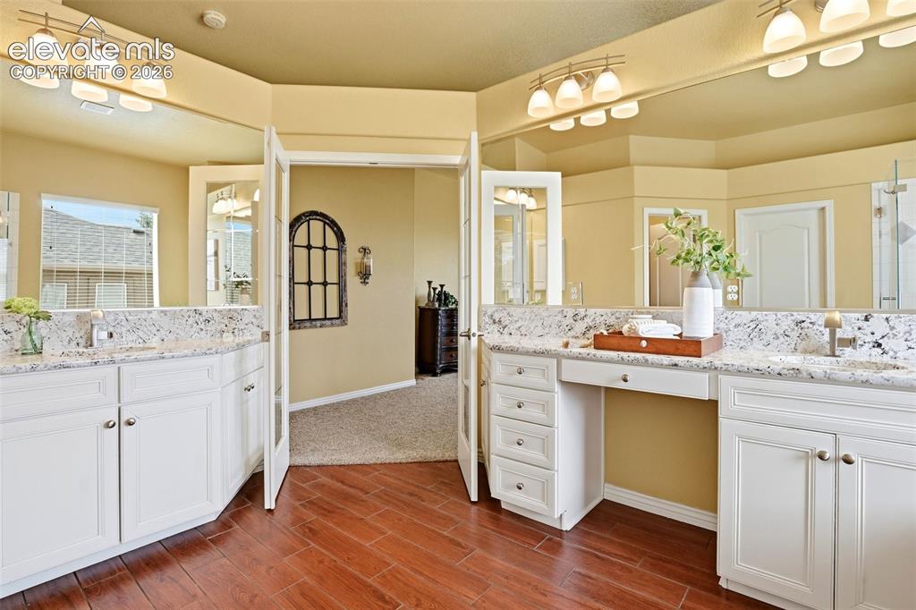 Image 13 of 41: Dual vanities with undermount sinks, expansive countertop space, white cabi