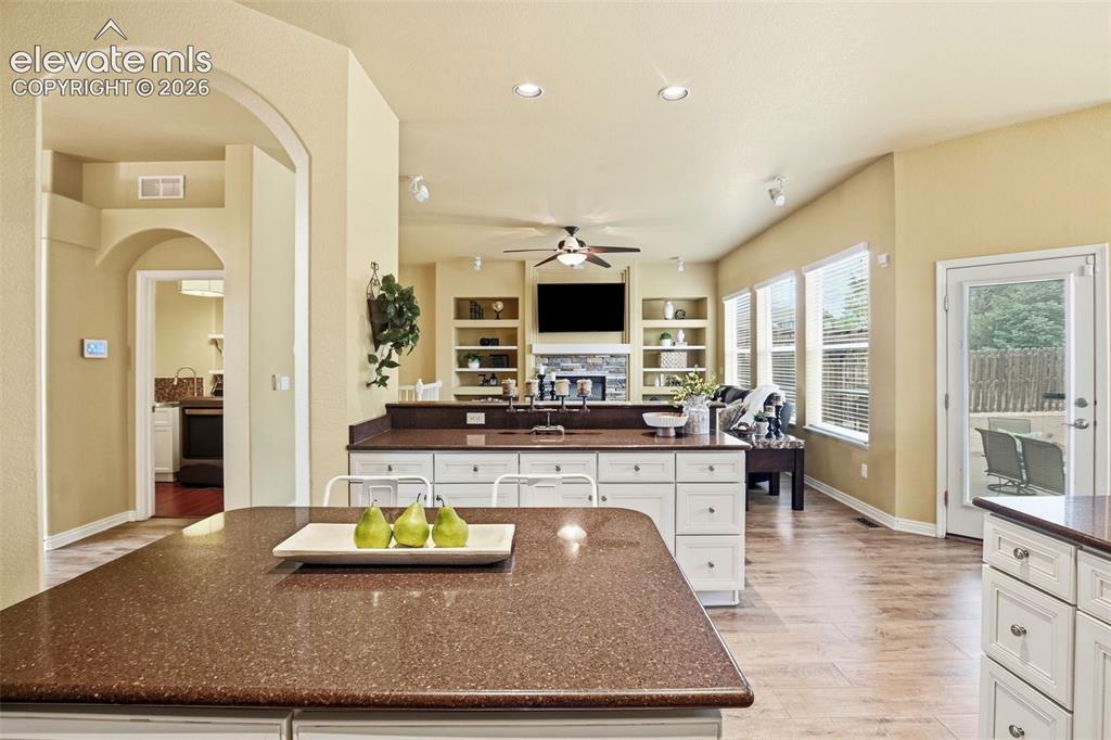 Image 18 of 41: Spacious kitchen island with a speckled countertop, white cabinetry, and re