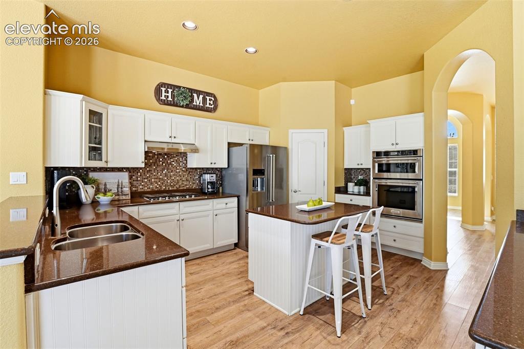 Image 20 of 41: KitchenAid appliances included with gas stove, recessed lighting, mosaic ti