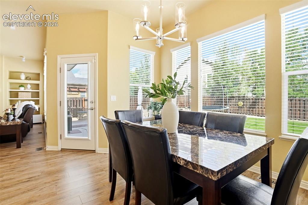 Image 22 of 41: Wood-finish flooring throughout, vaulted ceiling, built-in shelving, glass-